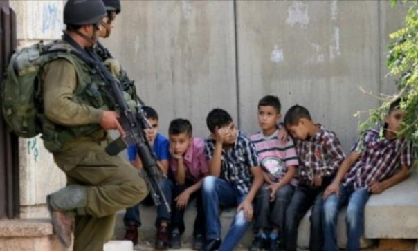 Militer Israel dengan senjata lengkap mengawal sejumah bocah Palestina yang tampak ketakutan. Foto: int 