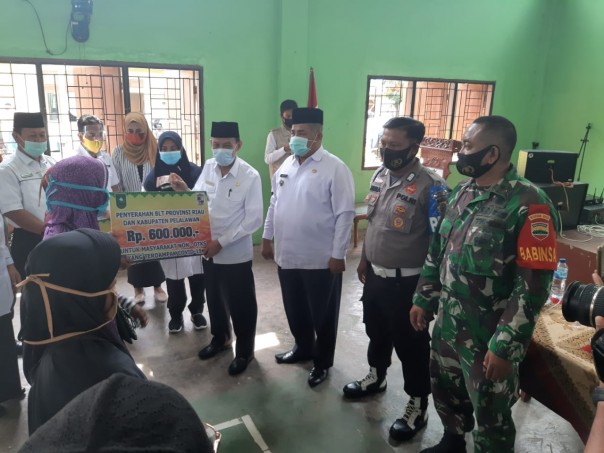 Polsek Pangkalan Lesung Kawal Penyerahan BLT Provinsi dan BLT Kabupaten Pelalawan