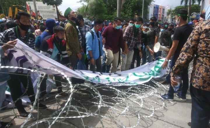 Aksi mahasiswa merusak pagar berduri dalam aksi demo Ciptaker di DPRD Riau