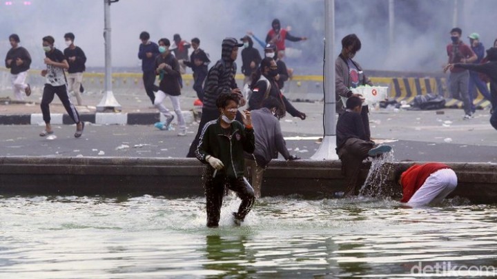 Massa berlarian menuju kolam guna menghindari tembakan gas air mata yang dilepas petugas Kepolisian. Foto: int 
