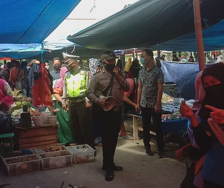 Personel Polsek Pangkalan Kuras bersama Satpol PP Kabupaten Pelalawan melakukan Operasi Yustisi dalam rangka pendisiplinan masyarakat pada masa pandemi corona, Minggu (13/12/2020). Foto: Istimewa. 