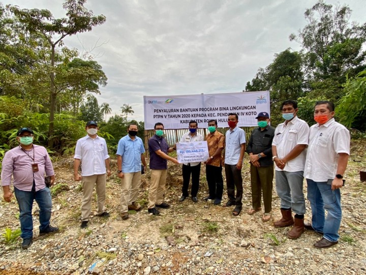 SEVP Business Support PTPN V Rurianto menyerahkan bantuan dana bina lingkungan untuk peningkatan kualitas jalan kepada Kepala Desa Pendalian Mulyadi, baru-baru ini di Kecamatan Pendalian IV Koto Rokan Hulu (foto/ist) 
