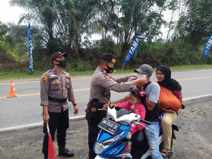 Personil Polsek Bandar Sei Kijang Bagi-bagi Masker ke Warga