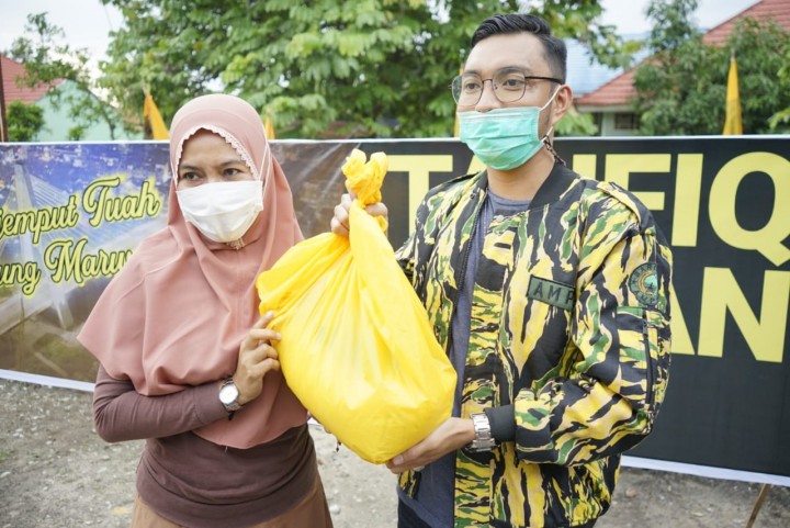 Bendahara AMPG Pekanbaru Bung Riban (Kanan) serahkan paket sembako lepada warga di Kelurahan Tobek Godang Kecamatan Tampan, AMPG Riau dalam giat Jumat Berkah bagikan puluhan paket sembako kepada masyarakat di Pekanbaru, Jumat (15/1/2021)