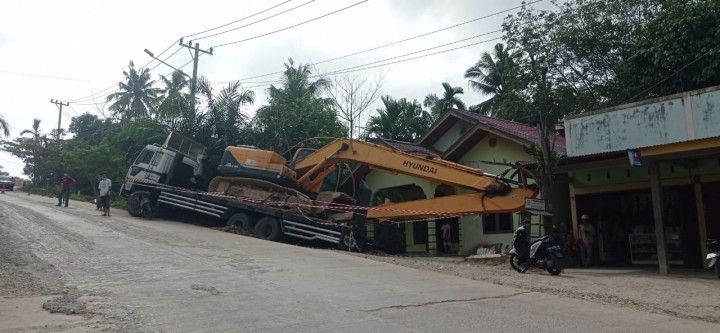 Truk yang mengangkut ekskavator di Jalan Badak nyaris mengenai rumah warga. Diduga truk tersebut tidak kuat menanjak di Jalan tersebut.