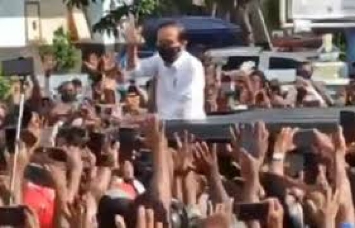 Jokowi melambaikan tangan di tengahbkerumunan warga