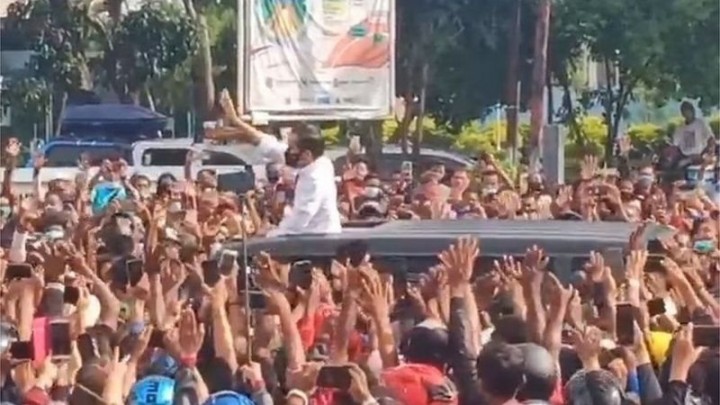 Jokowi melambaikan tangan di tengah kerumunan warga
