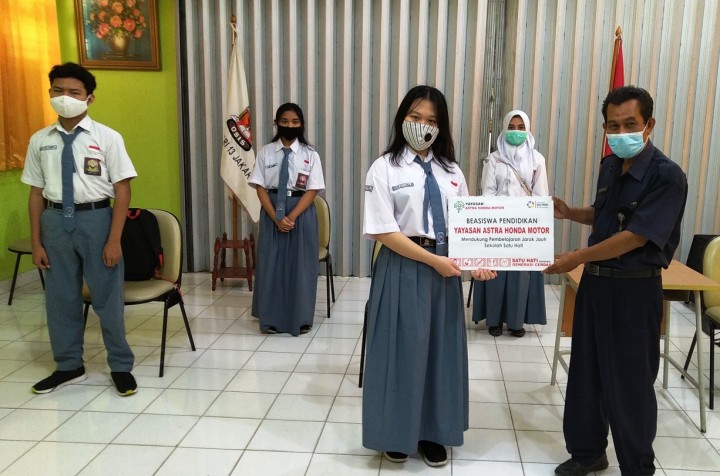 Penyerahan secara simbolis Beasiswa PJJ Yayasan AHM oleh Ade Nuryaman wakil kepala sekolah SMAN 13 Jakarta kepada perwakilan penerima Beasiswa. (Foto: Istimewa)