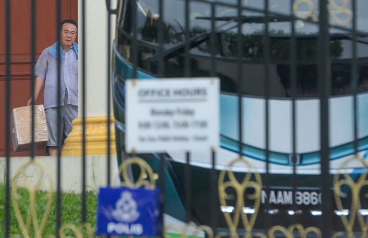 Konselor kedutaan Korut Kim Yu Song membawa kotak dalam kompleks kedutaan Korut di Kuala Lumpur Malaysia. Foto: Medcom.id