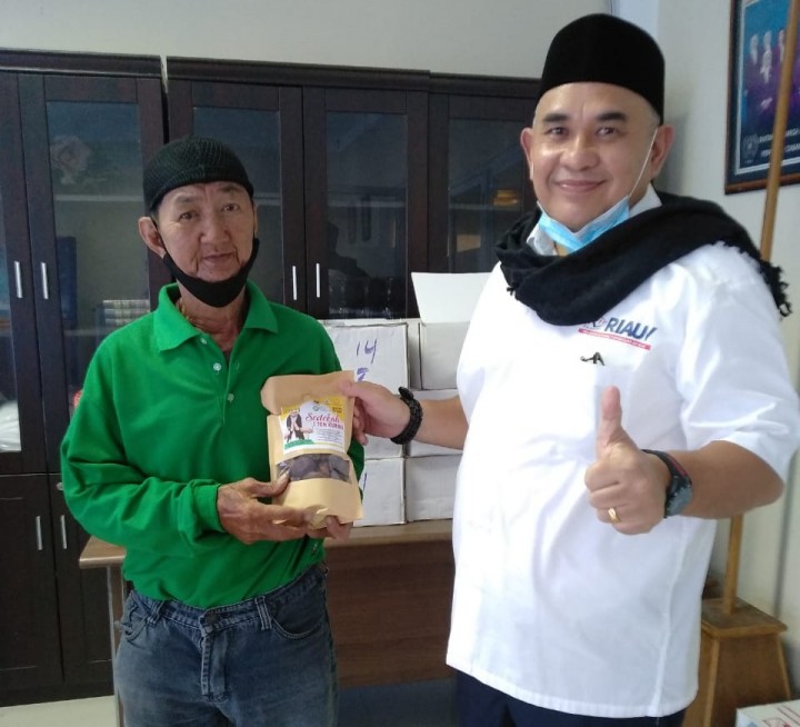 Ketua PWI Riau menyerahkan sedekah kurma kepada pengurus Mesjid