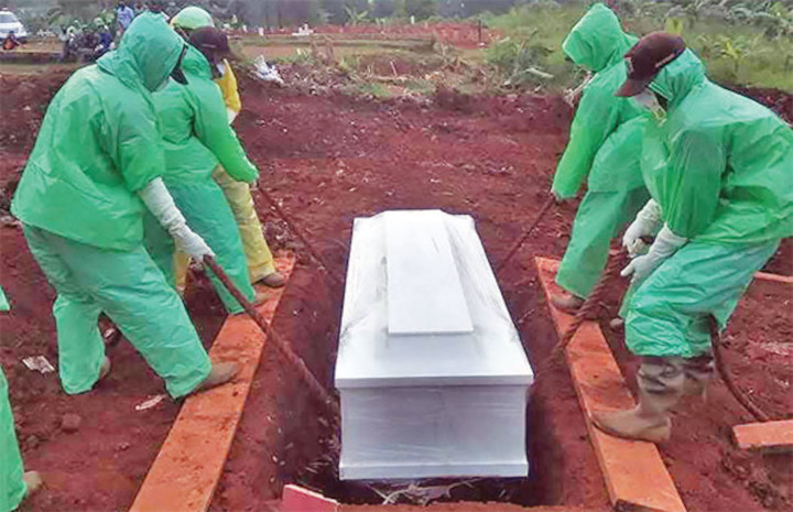 Petugas sedang memakamkan jenazah pasien Covid-19. Foto: Media Indonesia