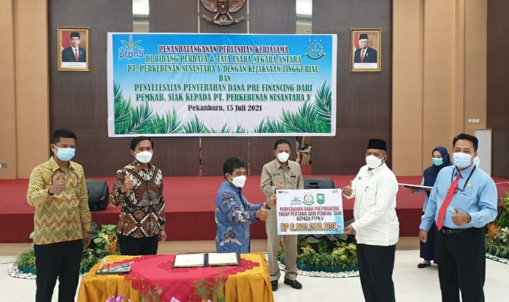 Bupati Siak, Alfedri (kemeja putih) menyerahkan secara simbolis pembayaran prefinancing senilai Rp6 miliar kepada PTPN V yang diwakili SEVP Operation, Ospin Sembiring, di Aula Kejaksaan Tinggi Riau, Kamis (15/7/2021) (foto/ist)