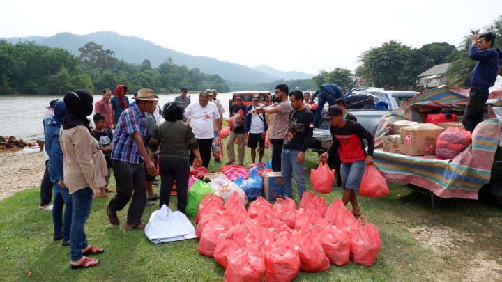 Warga desa Ludai bersama tim TLCI Riau tampak mendistribusikan bantuan 