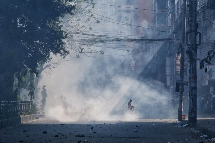 Asap gas air mata mengepul setelah polisi bentrok dengan umat Muslim selama protes atas dugaan penodaan Alquran, di luar masjid nasional Bangladesh Baitul Mukarram, Dhaka, Bangladesh, 15 Oktober 2021. (AP Photo) 