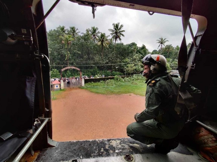 Seorang anggota angkatan laut melihat dari helikopter mereka dalam misi untuk mendistribusikan bahan bantuan kepada orang-orang yang terkena dampak banjir di Koottickal di distrik Kottayam, negara bagian Kerala selatan, India, 17 Oktober 2021. (Foto Angkatan Laut India via AP)
