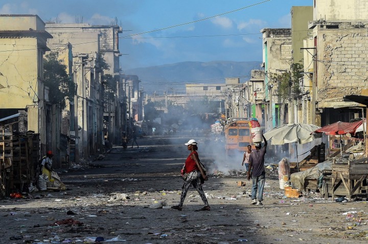 Orang-orang berjalan di jalan sepi menjelang penembakan geng di pusat kota Port-au-Prince, Haiti, 20 Desember 2019. (AFP Photo)