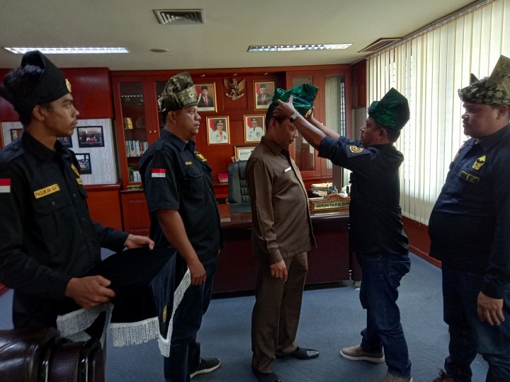 Sekwan DPRD Riau Muflihun menerima tanjak dari pasukan adat gagak hitam