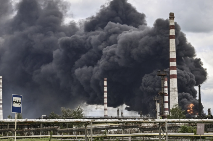 Foto : Asap mengepul dari kilang minyak setelah serangan di luar kota Lysychansk [Aris Messinis/AFP]