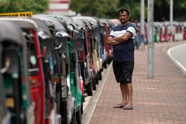 Seorang pengemudi becak menunggu dalam antrian berharap mendapatkan bahan bakar di dekat stasiun bahan bakar di Kolombo [File: Eranga Jayawardena/AP]