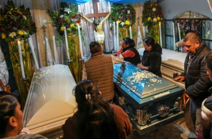 Kerabat di San Marcos Atexquilapan Meksiko berdiri di peti mati tiga remaja yang meninggal di sebuah truk terkunci di pinggiran San Antonio, Texas, 13 Juli 2022