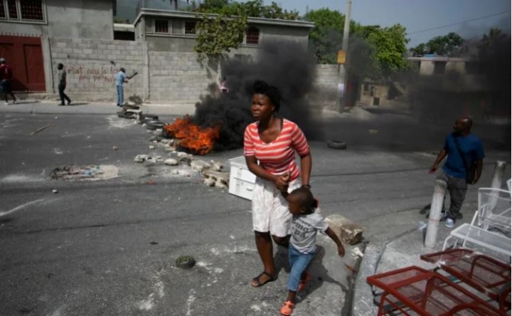 Foto : Seorang wanita dengan putranya berjalan melewati barikade yang didirikan oleh para demonstran untuk memprotes kekurangan bahan bakar di Port-au-Prince, Haiti