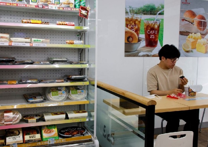 Foto : Seorang pekerja kantor makan siang di sebuah toko serba ada di Seoul, Korea Selatan, pada 24 Juni 2022 (Reuters)
