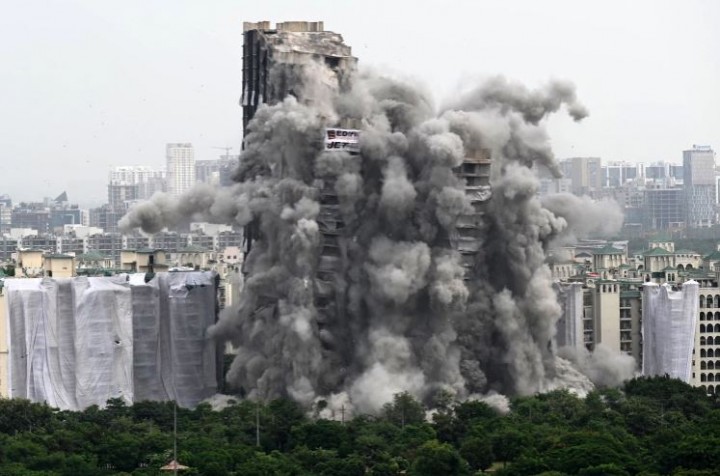 Dua gedung tinggi perumahan yang dibangun secara ilegal dihancurkan di dekat ibu kota India [Sajjad Hussain/AFP]