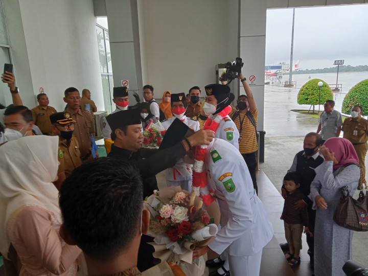 Ketua DPRD Riau Yulisman mengalungi bunga kepada dua Paskibraka 