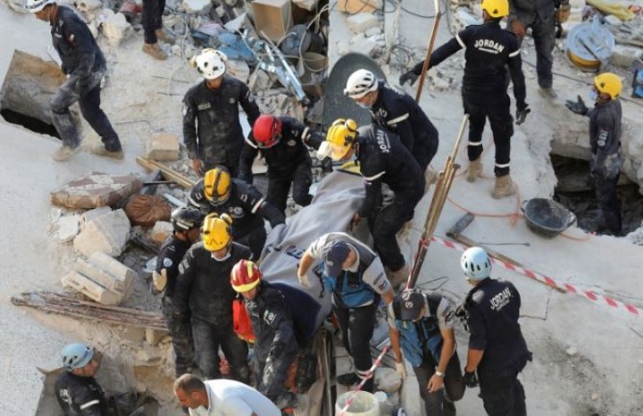 Tim penyelamat mengangkut korban di lokasi bangunan yang runtuh di Amman, Yordania [Alaa Al Sukhni/Reuters]