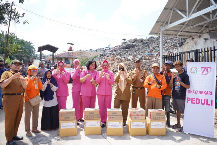 Ketua Bhayangkari Daerah Riau, Ny. Nindya M Iqbal melewati 'gunungan sampah' demi menyalurkan bantuan sosial (bansos) berupa sembako bagi para pekerja di Tempat Pembuangan Akhir (TPA) Muara Fajar, Rumbai, Kota Pekanbaru, Selasa 11 Oktober 2022 siang.