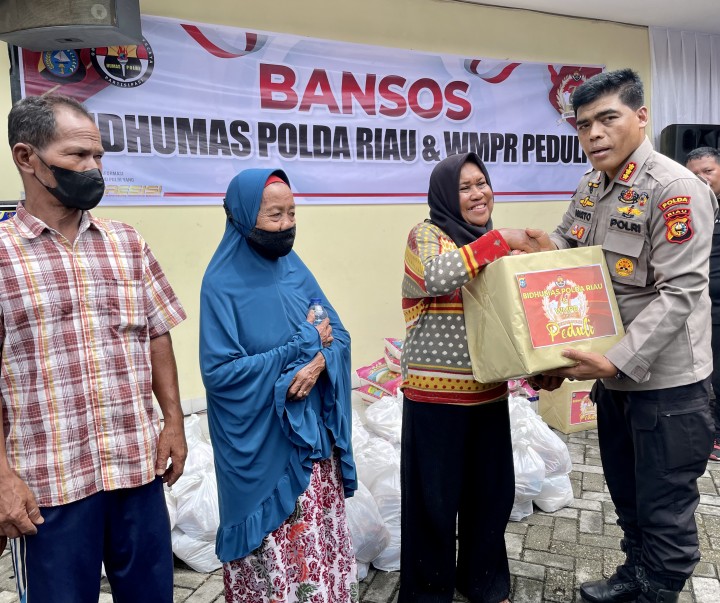 Kabid Humas Polda Riau Kombes Sunarto menyerahkan Bansos secara simbolis kepada warga.