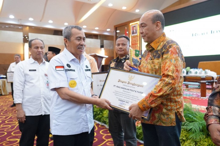 Gubri Syamsuar menyerahkan sertifikat penghargaan PMA dengan kategori sebagai perusahaan dengan  investasi  terbesar kepada Direktur Sosial Capital PT RAPP, Mulia Nauli