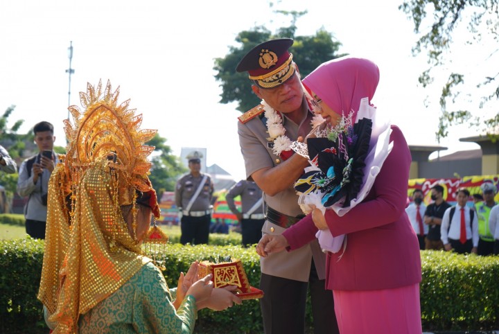 Brigjen Kasihan Rahmadi menyuapi sang istri dengan sirih yang disajikan penari di Mapolda Riau.( Foto Humas Polda Riau/Jumadi)