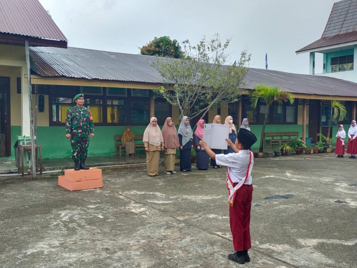 Personel Babinsa Kodim 0303 Bengkalis saat melaksanakan upacara di sekolah