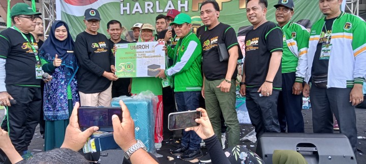 Waketum PPP Rusli Effendi (Kanan bertopi) dan ketua DPW PPP Riau Syamsurizal (kiri berbaju hitam dan bertopi) menyerahkan hadiah umroh kepada masyarakat yang beruntung dalam undian gerak jalan santai Harlah PPP ke 50 di stadion utama Riau 