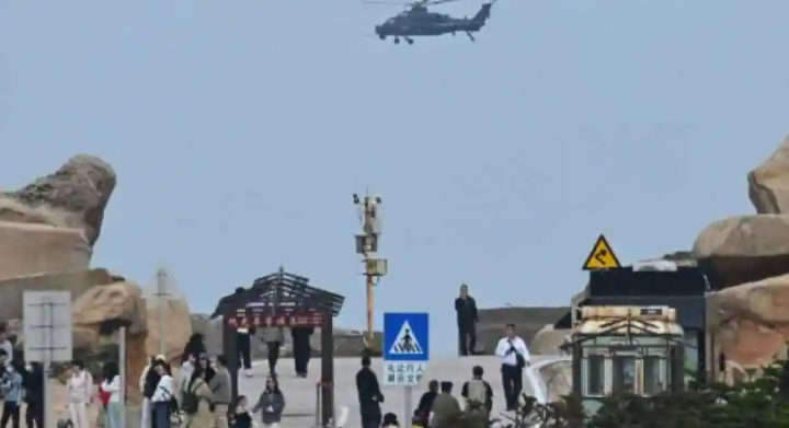 Sebuah helikopter militer China terbang melewati turis di titik pengamatan di atas Selat Taiwan /AFP