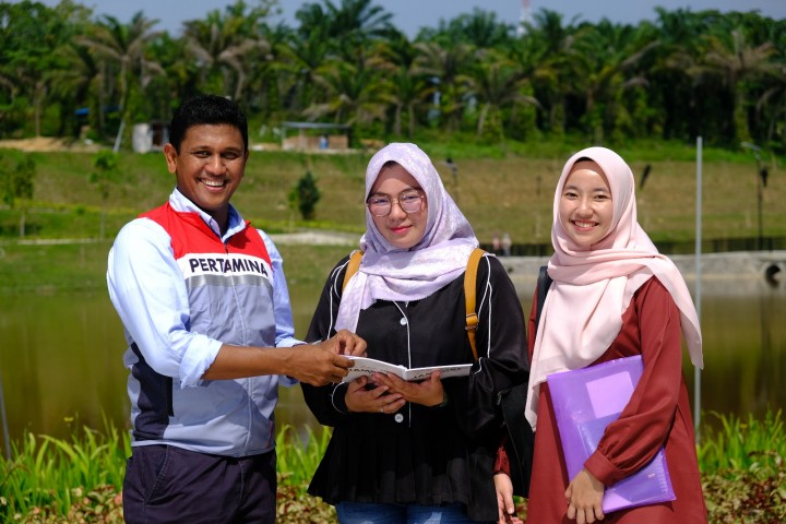 Dua peserta magang kerja PHR bersama mentor dalam suatu kegiatan TJSL di Pekanbaru, Riau