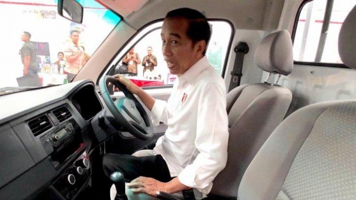 Presiden Joko Widodo terlihat hanya melontarkan senyuman saat ditanya perihal kritik Anies Baswedan terhadap kebijakan mobil listrik yang dianggapnnya justru menambah polusi udara. Sumber: tribunnews.com