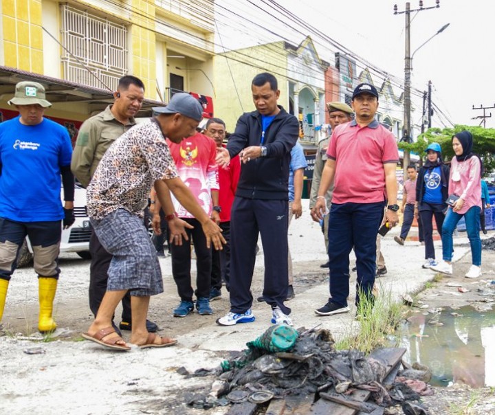 Pj Wali Kota Pekanbaru Muflihun (jaket hitam) saat berbincang dengan tokoh masyarakat setempat tentang sumber penyebab banjir di jalan tersebut. Foto: Istimewa.