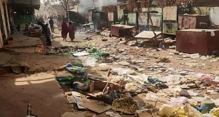 Orang-orang berjalan di antara benda-benda yang tersebar di pasar El Geneina, ibukota Darfur Barat saat pertempuran berlanjut di Sudan /AFP