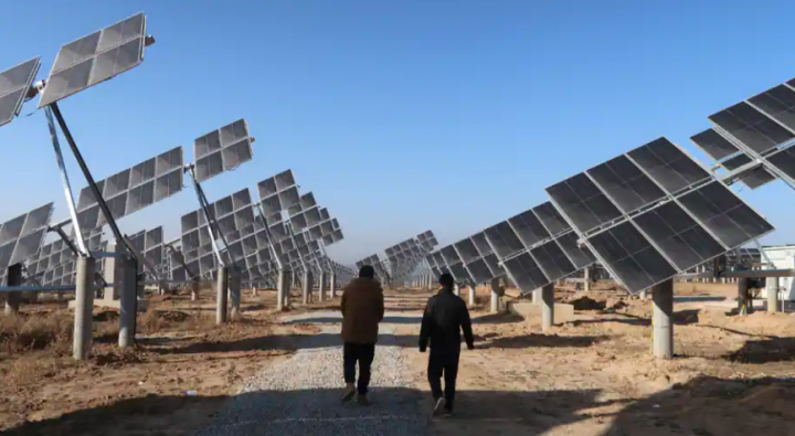 Pekerja berjalan di pembangkit listrik tenaga surya di Tongchuan, provinsi Shaanxi, China Rabu, 11 Desember 2019 /Reuters
