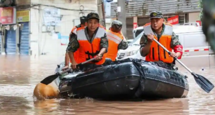 Foto yang diabadikan pada 4 Juli 2023 ini menunjukkan polisi paramiliter menggeledah suatu daerah setelah dibanjiri hujan lebat di Chongqing, China barat daya /AFP