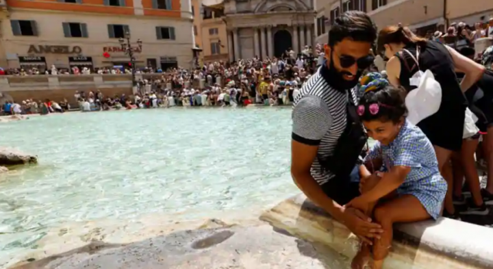 Orang-orang mendinginkan diri di Air Mancur Trevi selama gelombang panas di seluruh Italia /Reuters