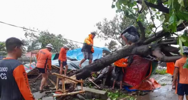 Anggota Penjaga Pantai Filipina memindahkan pohon tumbang dari jalan setelah serangan hebat Topan Doksuri di Buguey, provinsi Cagayan, Filipina, 26 Juli 2023 /Reuters