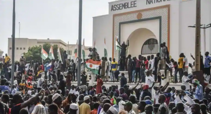 Para pendukung mengibarkan bendera Niger saat mereka berunjuk rasa untuk mendukung junta Niger di depan Majelis Nasional di Niamey pada 30 Juli 2023 /AFP