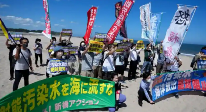 Orang-orang memprotes di pantai menuju pembangkit listrik tenaga nuklir Fukushima Daiichi /AP