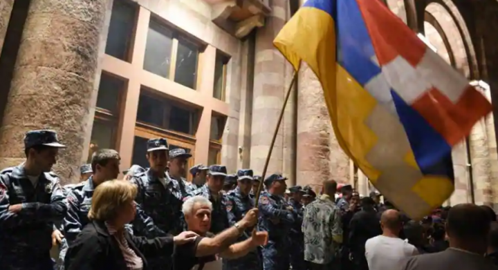 Petugas polisi Armenia menjaga pintu masuk gedung pemerintah selama bentrokan dengan pengunjuk rasa yang menyerukan Perdana Menteri Armenia Nikol Pashinyan untuk mengundurkan diri di Yerevan tengah pada 19 September 2023 /AFP