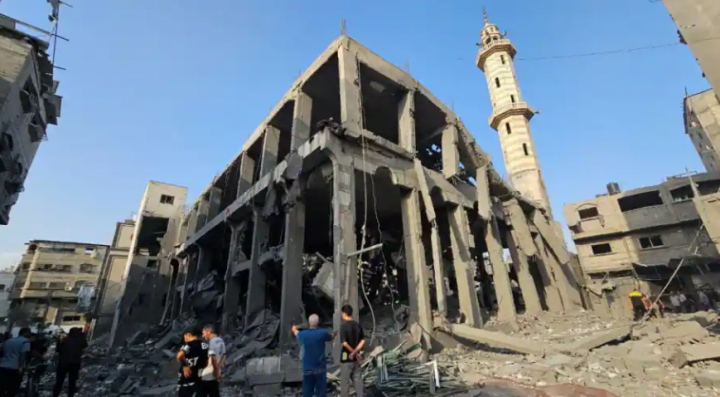Warga Palestina berkumpul di sekitar sisa-sisa masjid yang hancur dalam serangan Israel di Jalur Gaza utara 22 Oktober 2023 /Reuters