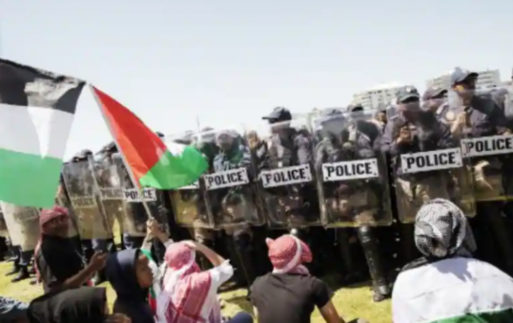 Petugas Departemen Kepolisian Metro Cape Town (CTMPD) berbaris ketika seorang pria mengibarkan bendera Palestina di Cape Town pada 12 November 2023, setelah pendukung pro-Israel diusir oleh kelompok lawan saat mereka berkumpul /AFP