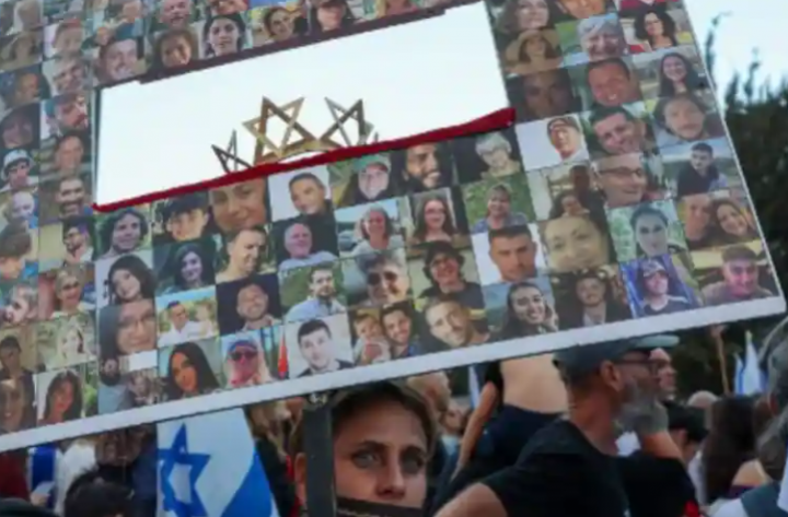 Seorang wanita memegang gambar sandera Israel ketika anggota keluarga, teman, dan pendukung memprotes menyerukan pembebasan mereka di luar kantor Perdana Menteri di Yerusalem pada 18 November 2023 /AFP